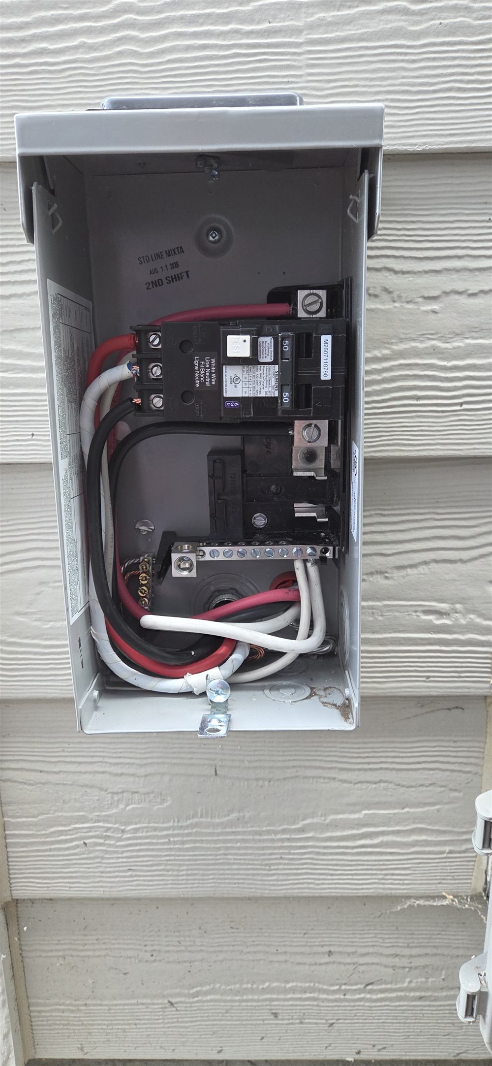 Hot tub GFCI disconnect installed on a house exterior